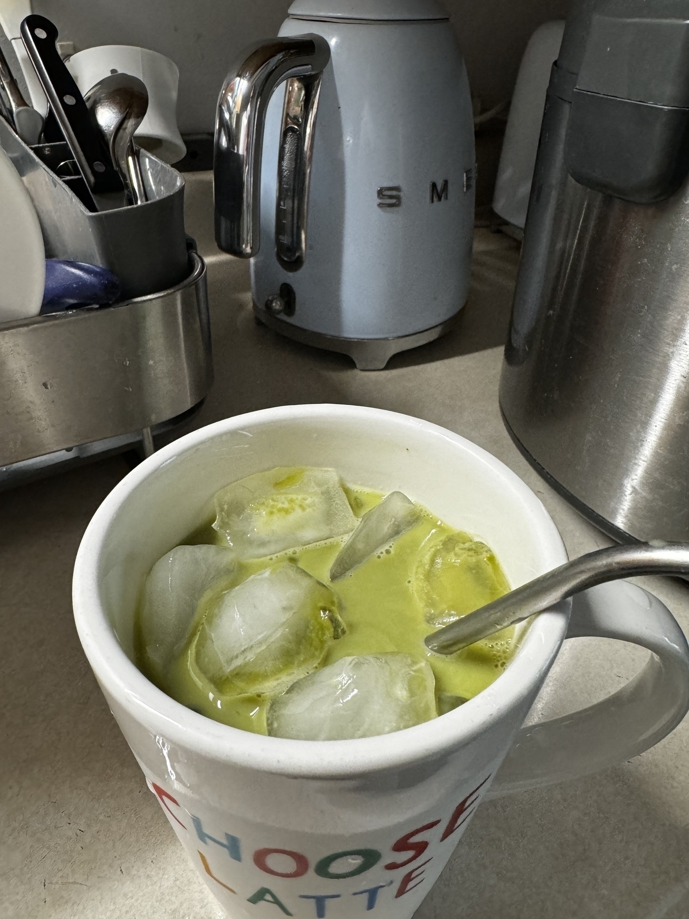 Matcha latte in a mug that says “choose latte”